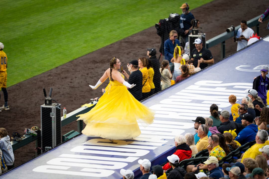 (Top) Matt Graifer—aka The Young Professor—takes the hype up a notch at a Savannah Bananas versus Indianapolis Clowns game at Coors Field in Denver on Aug. 15, 2026. (Bottom) Princess Potassia sings for Banana Ball fans at Coors Field in Denver on Aug. 15, 2026. (Madalina Kilroy/The Epoch Times)