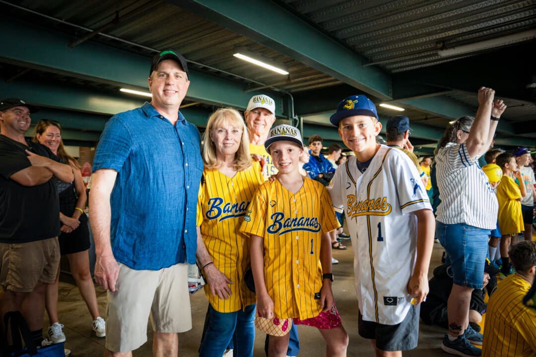 (L–R) Chris, Lara, David, and Will Bryan, and family friend Duke, ahead of the Savannah Bananas versus Indianapolis Clowns game at Coors Field in Denver on Aug. 15, 2026. Lara and David Bryan traveled from Shreveport, Louisiana, to attend the Savannah Bananas game with their children and grandchildren, who live in Colorado. (Madalina Kilroy/The Epoch Times)