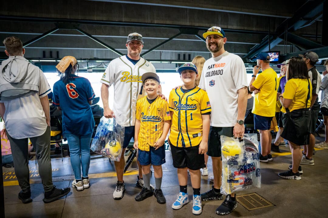 (L–R) Adam and Graysen Harshman, Vincenzo and Vinnie Mattivi, of Pueblo, Colo., ahead of the Savannah Bananas versus Indianapolis Clowns game at Coors Field in Denver on Aug. 15, 2026. (Madalina Kilroy/The Epoch Times)