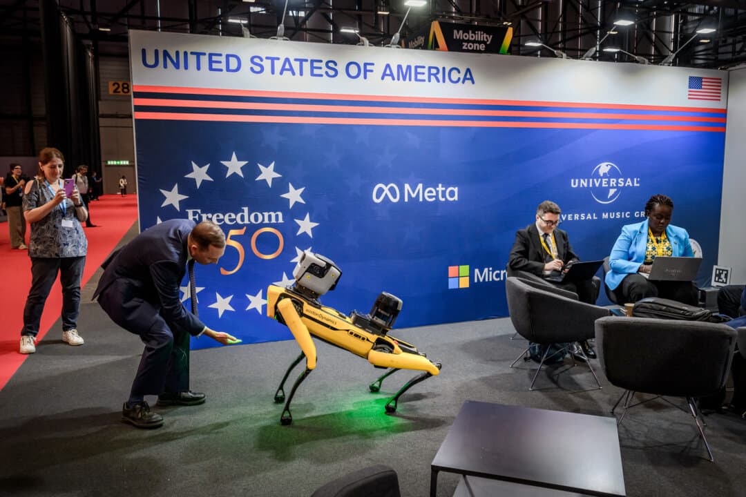 A visitor interacts with a dog-like robot from Boston Dynamics at the U.S. pavilion during the AI for Good Global Summit in Geneva on July 7, 2026. (Fabrice Coffrini/AFP via Getty Images)