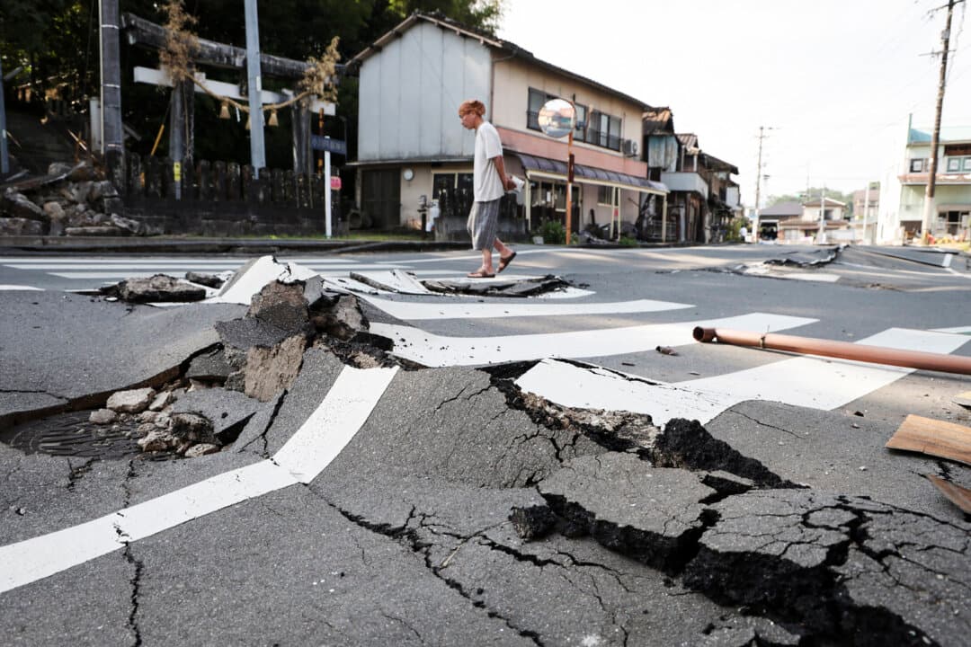 A man walks along a destroyed road in Uki, Kumamoto prefecture, Japan, on Aug. 3, 2026, after a July 28 earthquake. (Jiji Press/AFP via Getty Images)