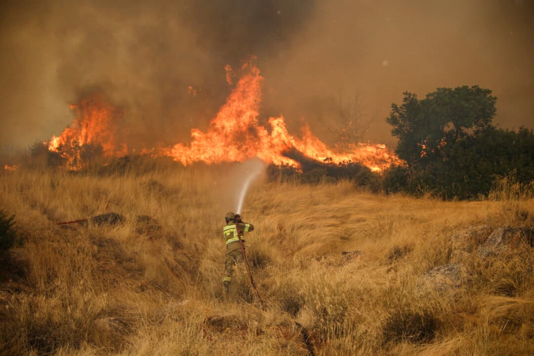 A firefighter works to extinguish a wildfire that has raged for four days in the Megara Region west of Athens on Aug. 3, 2026. Wildfires remained a threat despite easing winds and the deployment of firefighting aircraft. (Aris Oikonomou/AFP via Getty Images)