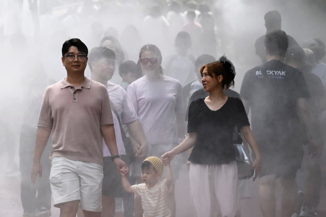 Visitors walk through a cooling mist at the Gwangmyeong Cave tourist site in Gyeonggi Province, South Korea, on Aug. 5, 2026. South Korea has been sweltering in a summer heat wave that has set new all-time highs three times over the past week alone. (Greg Baker/AFP via Getty Images)