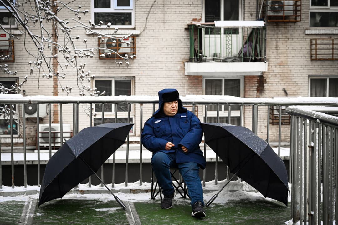 A security guard keeps watch on a pedestrian overpass as the opening session of the National People’s Congress was being held in Beijing on March 5, 2026. (Greg Baker/AFP via Getty Images)