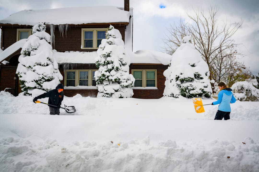 Two teenagers shovel snow from the sidewalk in front of one of their aunt's houses in Erie, Penn., on Dec. 2, 2024. Shoveling snow is one of many job options available for teenagers. (Jeff Swensen/Getty Images)
