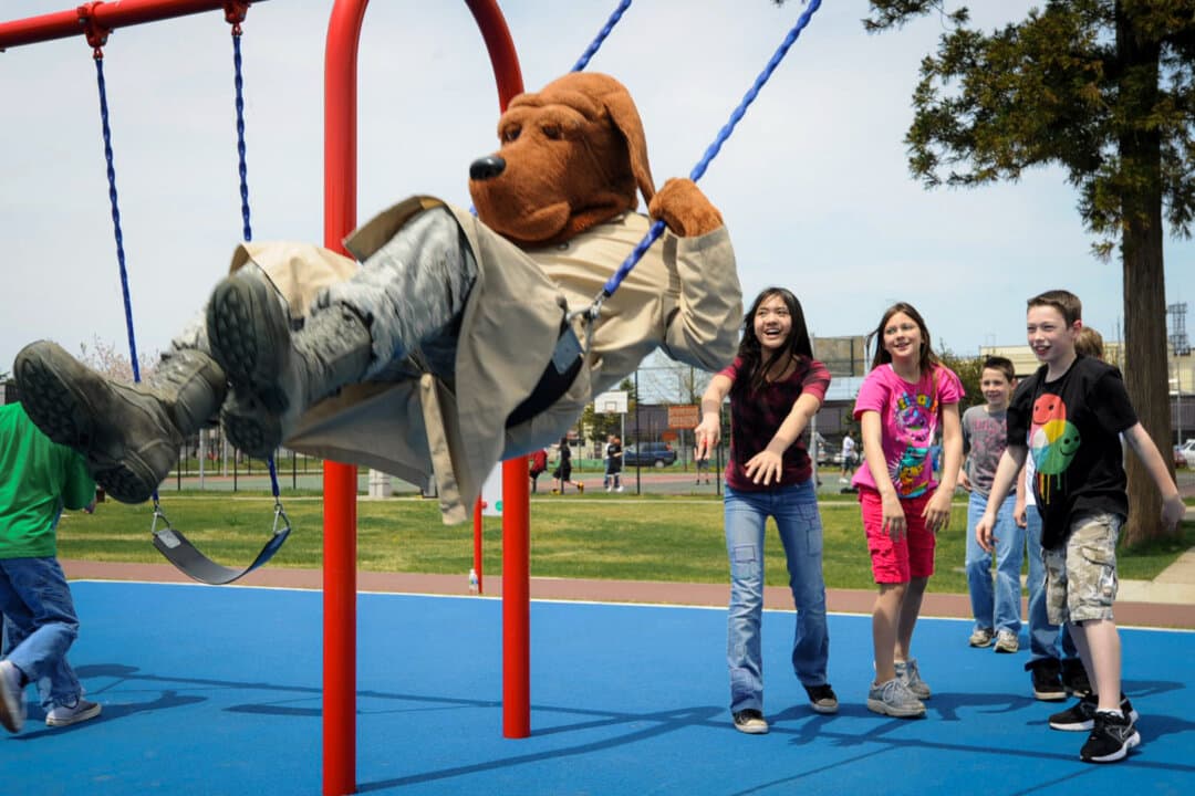 In support of Police Week, Sollars Elementary School students push McGruff the Crime Dog on the swings during recess at Misawa Air Base, Japan, on May 14, 2012. McGruff reminds children to stay away from drugs and to prevent bullying by saying “McGruff is watching you.” (Airman Kenna Jackson/U.S. Air Force 35th Fighter Wing via DVIDS)