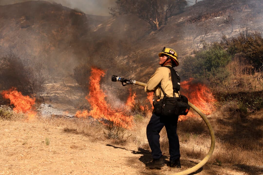 A Los Angeles firefighter battles the Walnut Fire in the Wildwood Canyon shortly after the fire broke out in Burbank, Calif., on Aug. 8, 2026. (David Swanson/AFP via Getty Images)