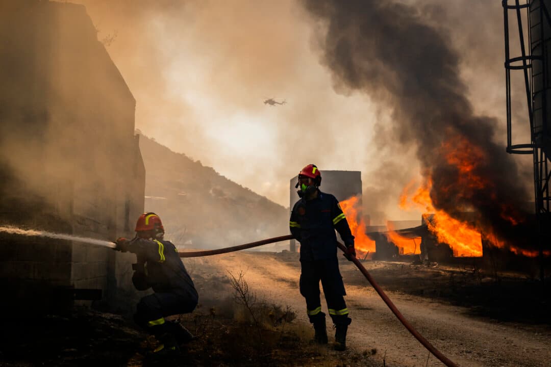 Firemen work to extinguish a fire that broke out at a livestock facility near Kouvaras, south of Athens, Greece, on Aug. 10, 2026. (Aris Messinis/AFP via Getty Images)