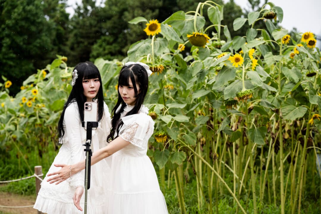 Two women pose for a photo as they visit a sunflower field at Kasai Rinkai Park in Tokyo on Aug. 11, 2026. (Andrew Caballero-Reynolds/AFP via Getty Images)