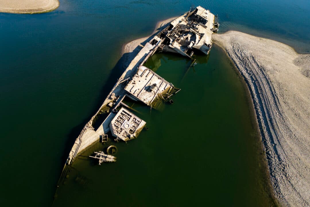 The wreckage of a World War II German warship, one of dozens sunk by retreating Nazi forces in September 1944, emerging from the low waters of the Danube River near Prahovo, Serbia, on Aug. 11, 2026, as drought and prolonged hot and dry weather continues to lower water levels across the region. Heat and drought are driving rivers across Europe to record lows. (Andrej Isakovic/AFP via Getty Images)