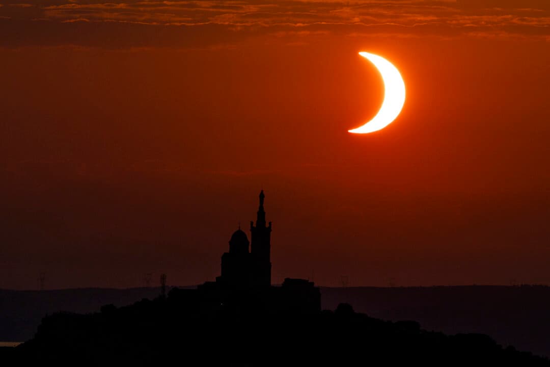 The moon passes over the sun's horizon behind the Notre-Dame de la Garde Basilica during a partial solar eclipse in Marseille, in southeastern France, on Aug. 12, 2026. In France, the solar eclipse was not total; after the total solar eclipse of 1999, France will not see another total eclipse for another 55 years in 2081. (Thibaud Moritz/AFP via Getty Images)