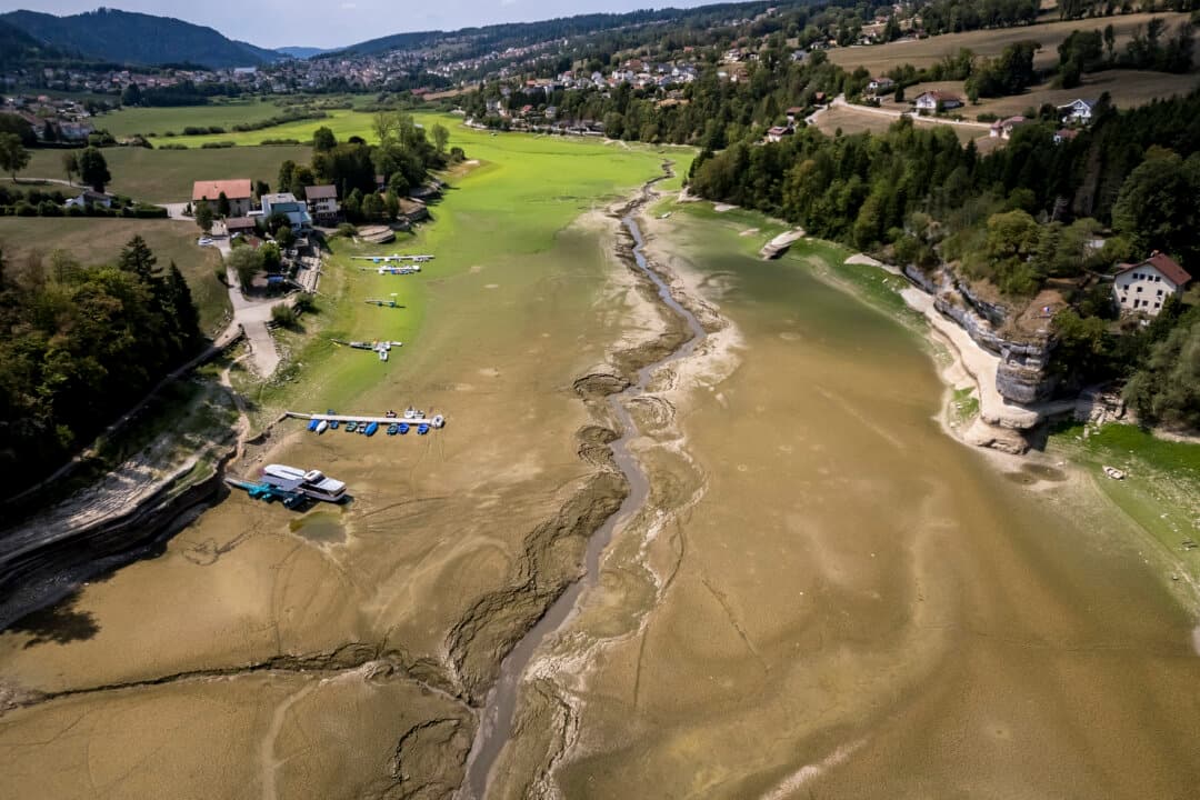 Boats stranded on the parched bed of Brenets Lake, part of the Doubs River, a natural border between eastern France and western Switzerland, as central Europe is hit by a new heatwave, in Les Brenets, Switzerland, on Aug. 11, 2026. (Fabrice Coffrini/AFP via Getty Images)