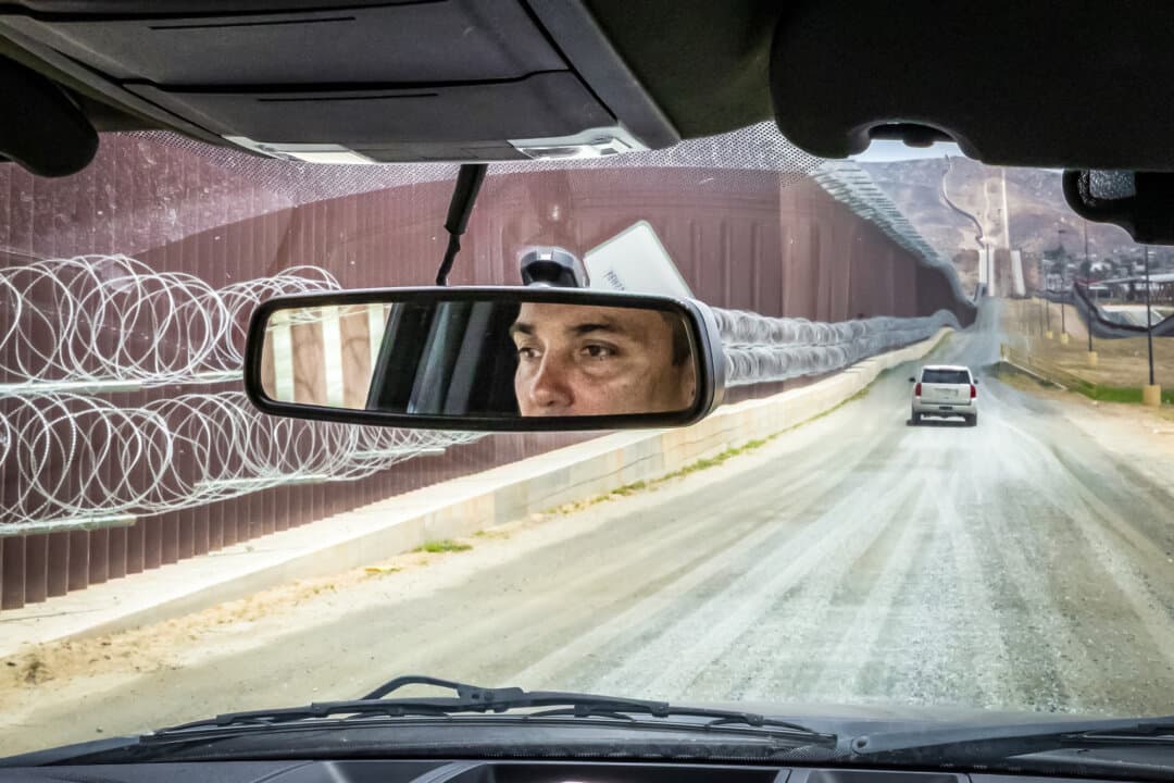Justin M. De La Torre, chief patrol agent for the U.S. Border Patrol's San Diego Sector, monitors the southern border wall outside of San Diego on May 27, 2026. (John Fredricks/The Epoch Times)