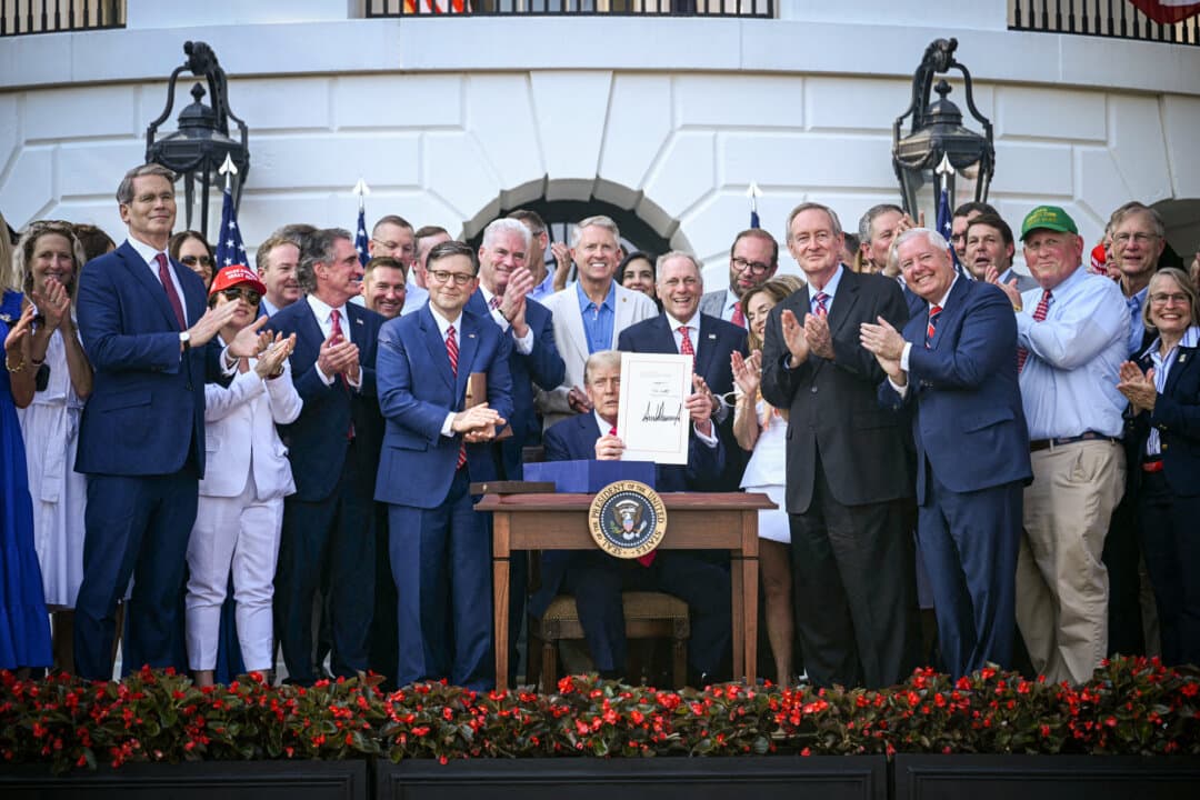 President Donald Trump shows his signature on the One Big Beautiful Bill Act at the White House on July 4, 2025. Since the bill took effect, participation in the food stamp program dropped by 12 percent, according to Department of Agriculture data released in July. (Brendan Smialowski/Pool/ AFP via Getty Images)