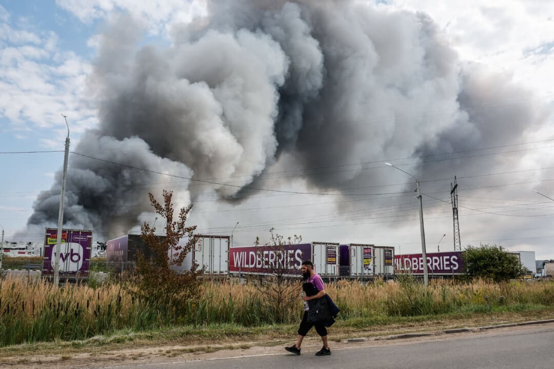 A Wildberries employee passes a plume of smoke during a fire at the Russian e-commerce firm's logistics complex near Podolsk, outside Moscow, on Aug. 16, 2026. (Tatyana Makeyeva/AFP via Getty Images)