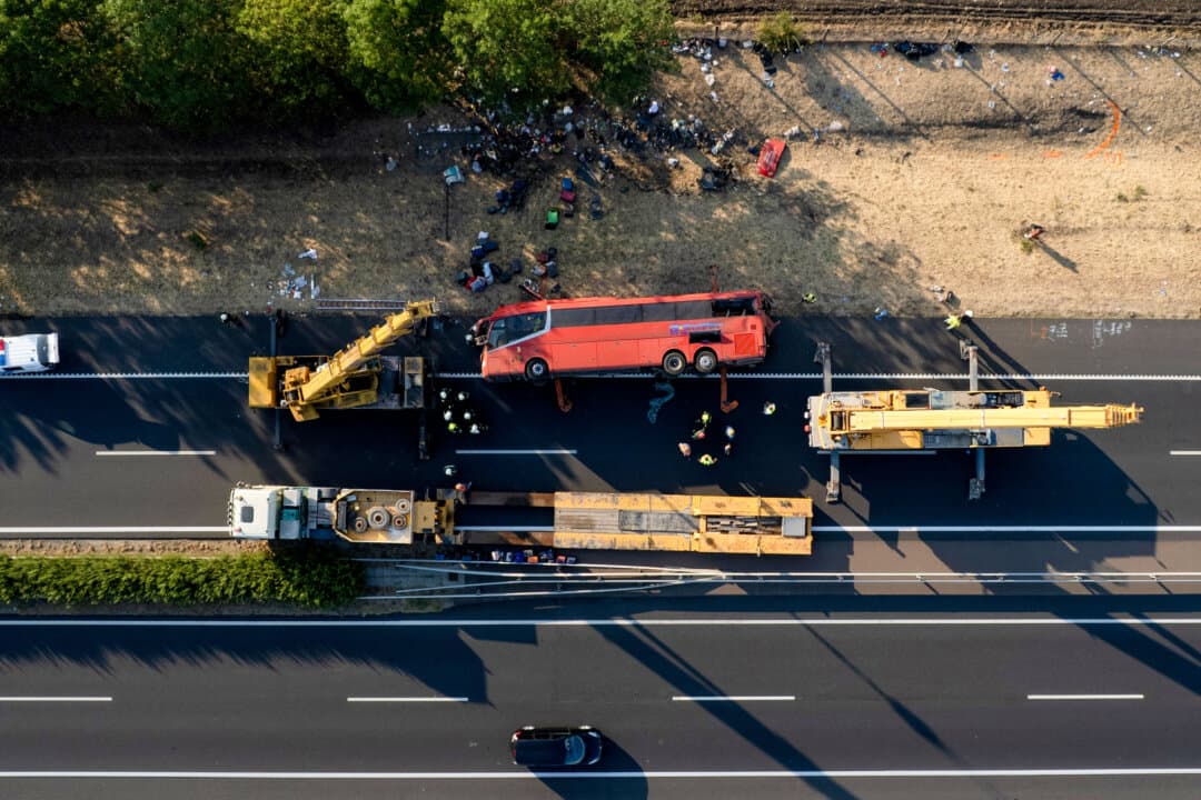 Rescue crews work at the wreckage of an overturned Polish tourist bus on the M3 motorway near Mezokeresztes, Hungary, on Aug. 16, 2026. The bus, traveling from Serbia to Poland, overturned early Sunday, killing 12 people and seriously injuring at least 10, according to Hungarian officials. (Zoltan Mathe/MTI/AFP via Getty Images)