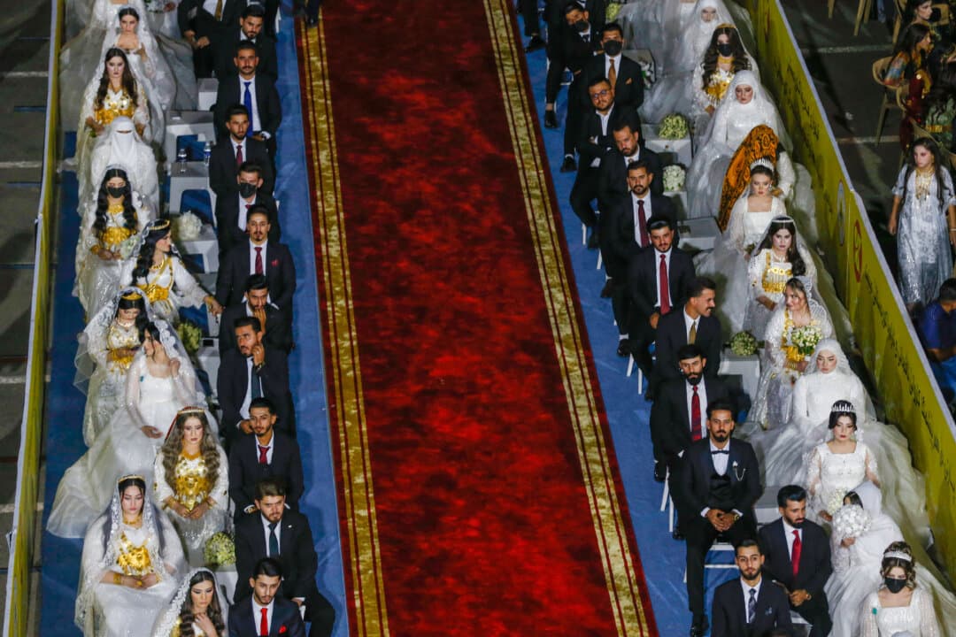 Ninety couples sit in rows during a mass wedding ceremony marking the 80th anniversary of the founding of the Kurdistan Democratic Party in Akre, Iraq, on Aug. 16, 2026. (Safin Hamid/AFP via Getty Images)