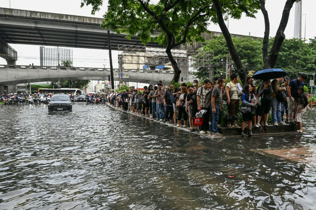 People stand along a street flooded by a monsoon in Manila, Philippines, on Aug. 17, 2026. (Jam Sta. Rosa/AFP via Getty Images)