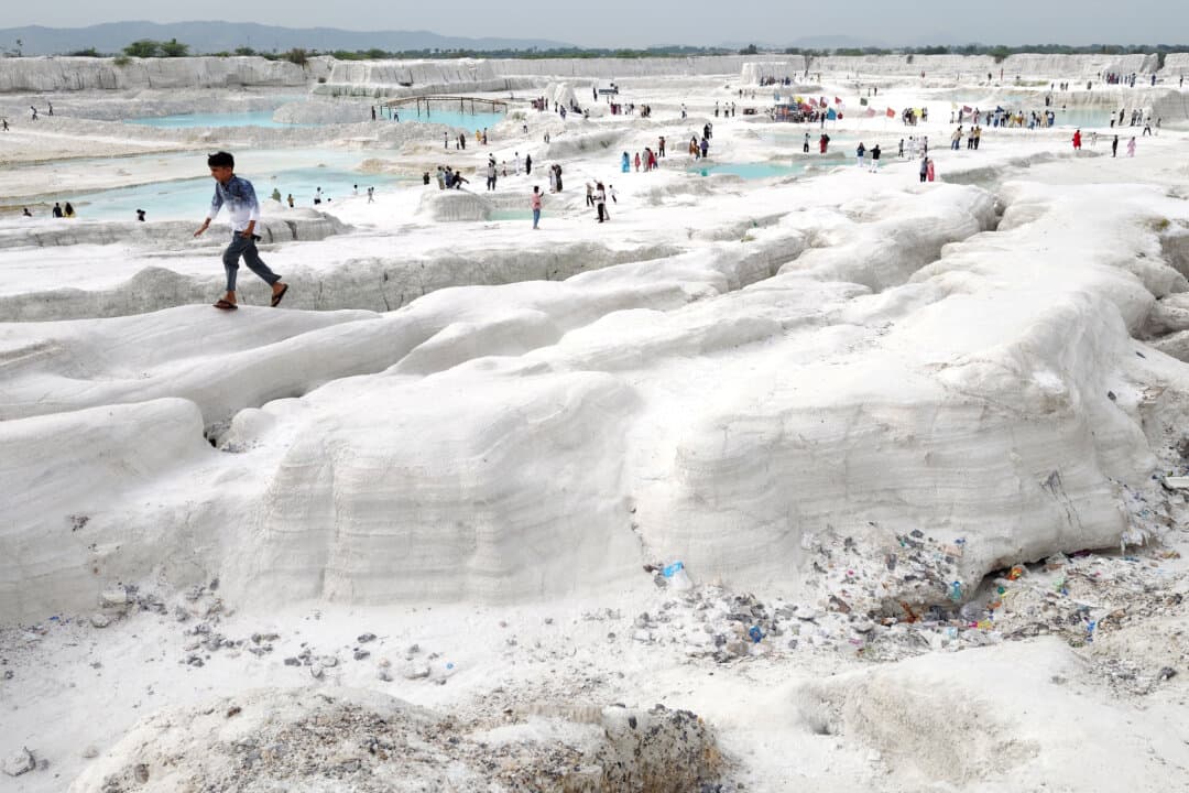 A boy walks atop mounds of dust at a marble-waste dumping yard in Kishangarh, India, on Aug. 16, 2026. The sprawling expanse of white marble waste has attracted tourists, filmmakers, and social media enthusiasts to a landscape resembling a snow-covered valley. (Himanshu Sharma/AFP via Getty Images)