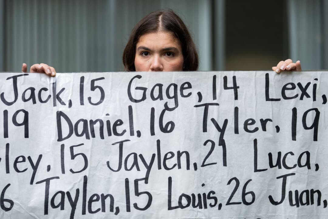 Olivia Konar holds a banner with the names of nearly 400 young people who allegedly died from the impacts of social media outside a U.S. courthouse as opening arguments begin in a lawsuit trial in Oakland, Calif., on Aug. 18, 2026. A coalition of U.S. states is seeking around $200 billion in damages from Meta, accusing the company of intentionally designing Facebook and Instagram to be addictive for children. (Godofredo A. Vásquez/AFP via Getty Images)