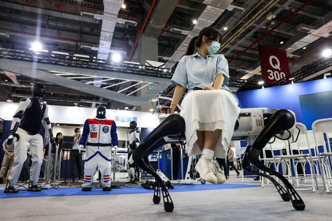 A visitor sits on a quadruped robot designed for inspection tasks during the Taiwan Automation Intelligence and Robot Show in Taipei, Taiwan, on Aug. 20, 2026. (I-Hwa Cheng/AFP via Getty Images)