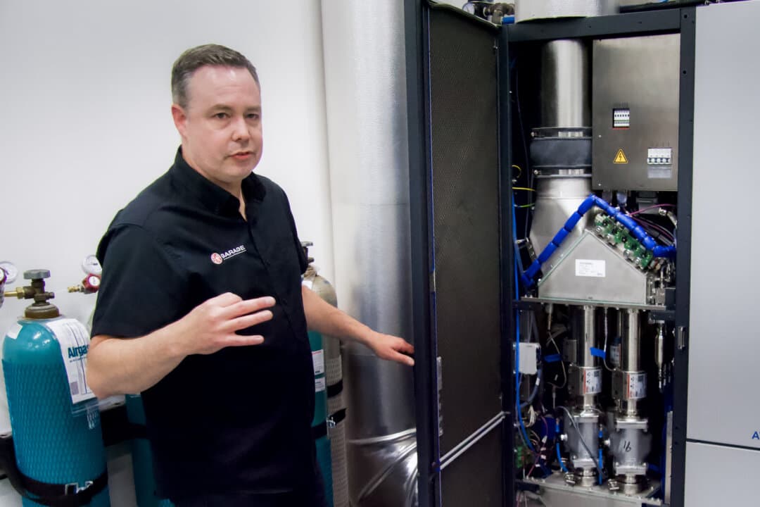 Ben Kaminsky, general manager of SEMA’s Detroit Garage, shows advanced emissions technology used in the testing facility in Plymouth, Michigan, on July 28, 2026. (Travis Gillmore/The Epoch Times)