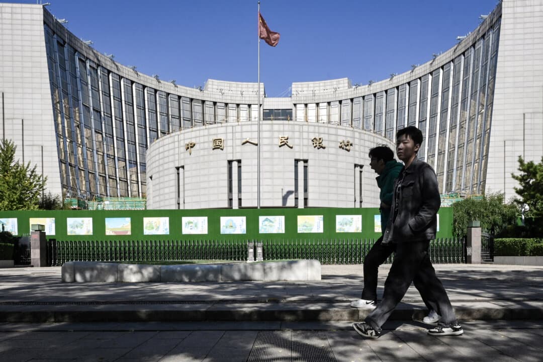 People walk past the People's Bank of China, the country's central bank, in Beijing on Oct. 19, 2024. (Adek Berry/ AFP via Getty Images)