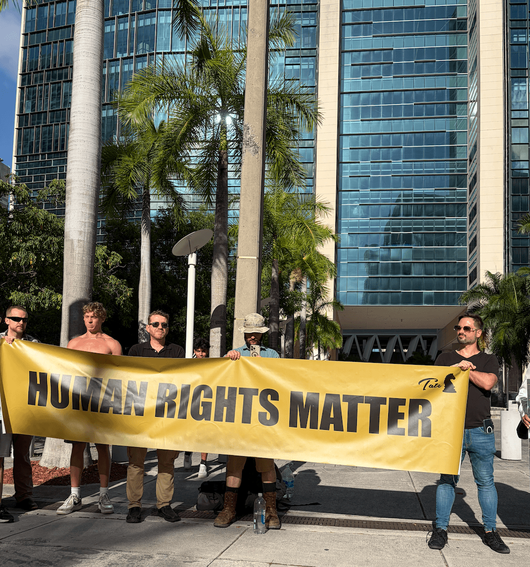 Supporters of Andrew and Tristan Tate held signage reading “Human Rights Matter” and “Free the Tates.” A group of about 30 remained outside the Miami federal courthouse from the morning until later in the afternoon for the influencer brothers’ custody hearing on Aug. 27, 2026. (Troy Myers/Epoch Times)