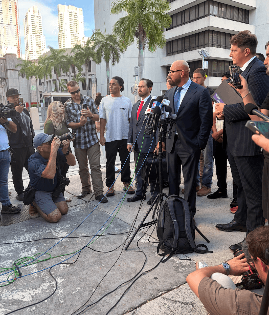 Andrew and Tristan Tate’s attorneys hold a press conference after the brothers’ custody hearing, accusing the Department of Justice of “mocking” and politically attacking their clients. The judge did not decide whether to grant the Tates release on bail during the hearing in Miami on Aug. 27, 2026. (Troy Myers/Epoch Times)