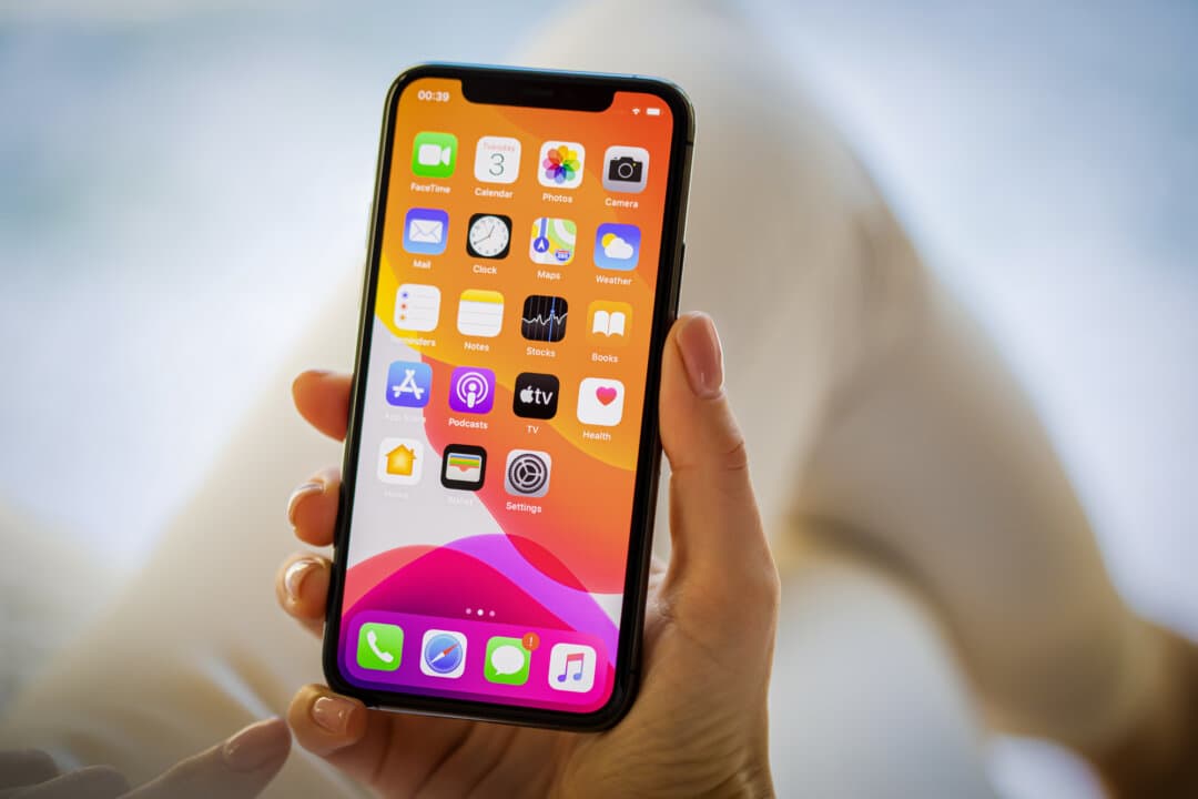 A woman holds an Apple iPhone 11 Pro, in this file photo. Mobile phone apps allow millions of Americans to easily bet on politics, sports, and other subjects. (grinvalds/Getty Images)