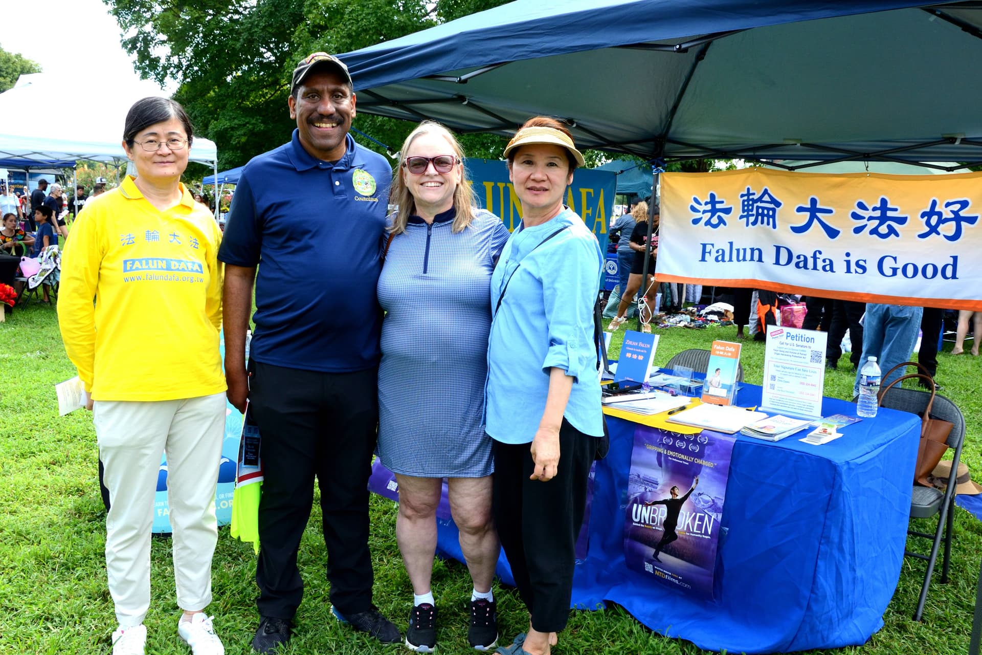 Dover Councilman David Anderson (2nd L) and his wife Jennie Anderson (2nd R) in front of the Falun Gong booth at the 4th annual Baila Con Dover Latin Festival on Aug. 29, 2026. (Frank Liang/The Epoch Times)