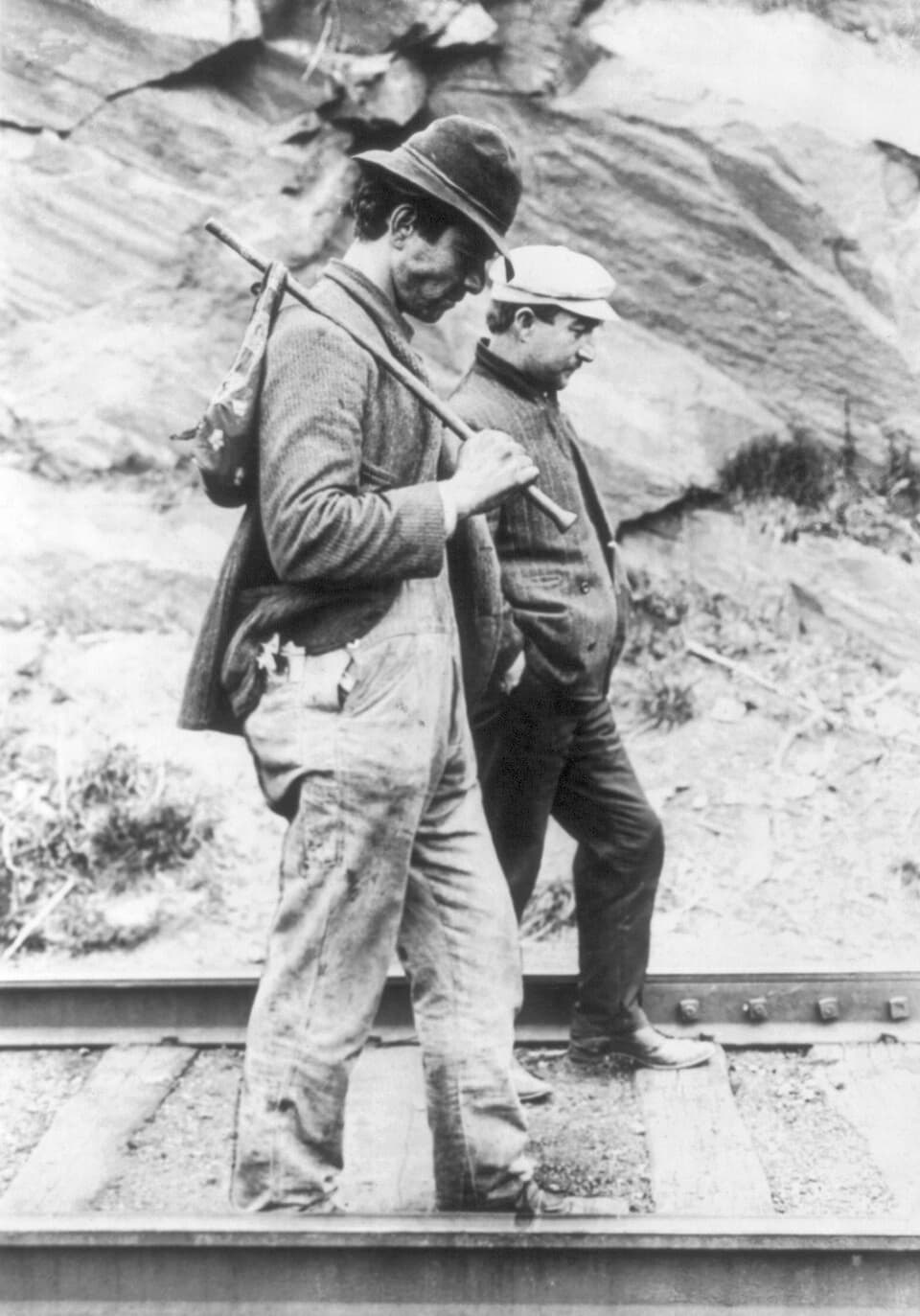 Hobos walk along train tracks after being removed from a train. (Public Domain)