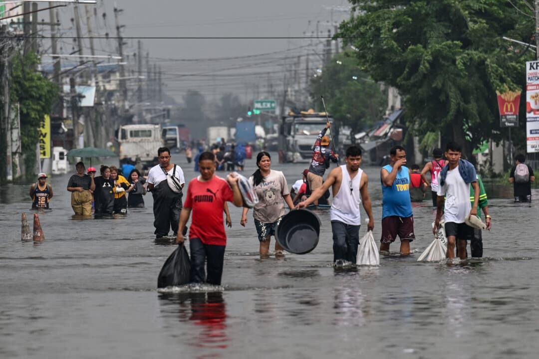 People wade through a flooded street after heavy rains brought by the southwest monsoon, in Pampanga, Philippines, on Aug. 31, 2026. (Jam Sta. Rosa/AFP via Getty Images)