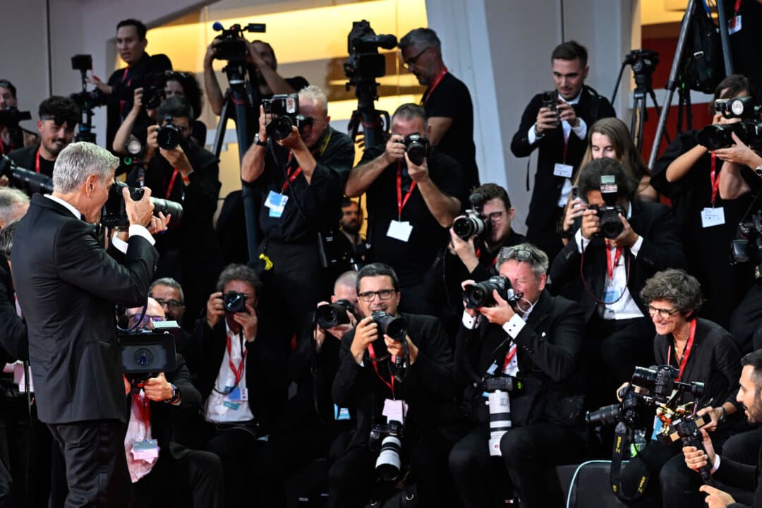 Actor and filmmaker George Clooney takes a picture of AFP photographer Tiziana Fabi after swapping his Golden Lion for Lifetime Achievement with Fabi's camera following the opening ceremony of the 83rd Venice International Film Festival, at Venice Lido, Italy, on Sept. 2, 2026. (Andrea Pattaro/AFP via Getty Images)