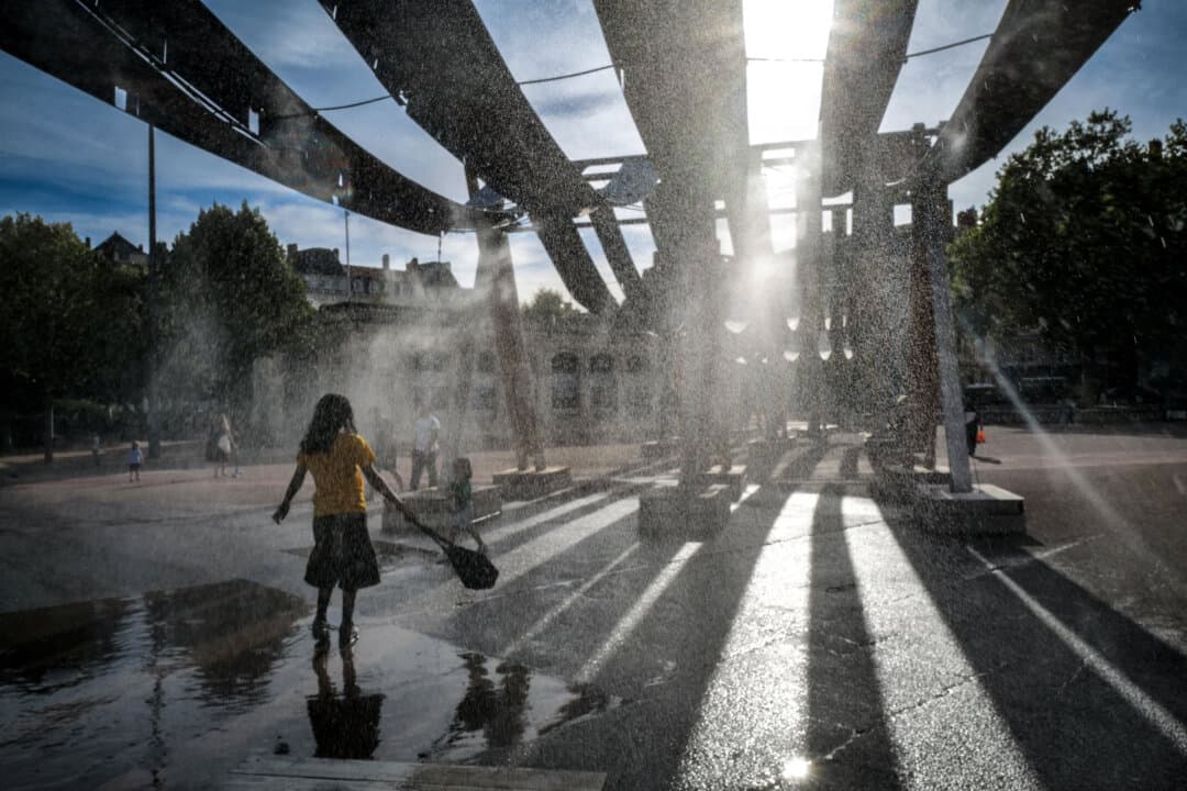 Pedestrians walk through water sprays on Place Bellecour during a heatwave, in Lyon, France, on Sept. 2, 2026. (Olivier Chassignole/AFP via Getty Images)