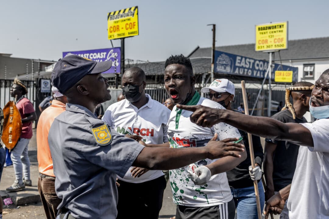 A South African Police Service officer stops an injured member of the March and March Movement after clashes with foreign nationals during a demonstration against undocumented migrants, in Durban, South Africa, on Sept. 3, 2026. (Rajesh Jantilal/AFP via Getty Images)
