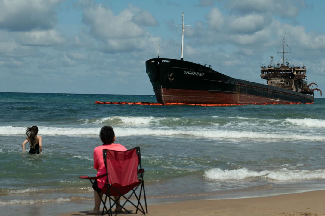 People swim near the Russian-flagged cargo ship OMSKIY-107 which was attacked off Russia’s coast before drifting across the Black Sea and running aground near Alacali Beach, Istanbul, on Sept. 3, 2026. (Cem Taylan/AFP via Getty Images)