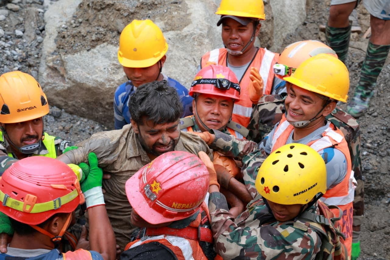 Survivor Sanjay Sah is carried by members of a search and rescue team after they rescued two people who had been trapped inside a tunnel at the Upper Trishuli-3A Hydropower Project following devastating floods and mudslides that struck the Bhotekoshi River in Rasuwa, Nepal, on Sept. 4, 2026. (Nepal Army/Handout via Reuters)
