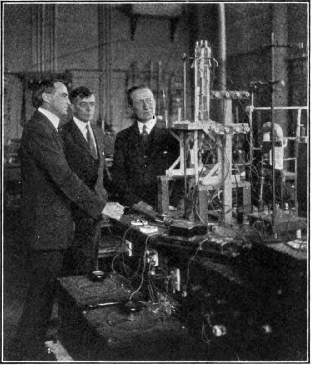 Langmuir (C) in 1922 in his lab at GE, showing radio pioneer Guglielmo Marconi (R) a new 20 kW triode tube. (Pubic Domain)