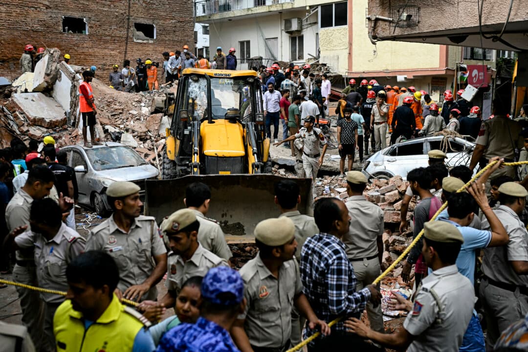 Security personnel cordon off the area as a bulldozer clears debris at the site following a building collapse in the Satya Niketan area in New Delhi, India, on Sept. 6, 2026. (Sajjad Hussain/AFP via Getty Images)