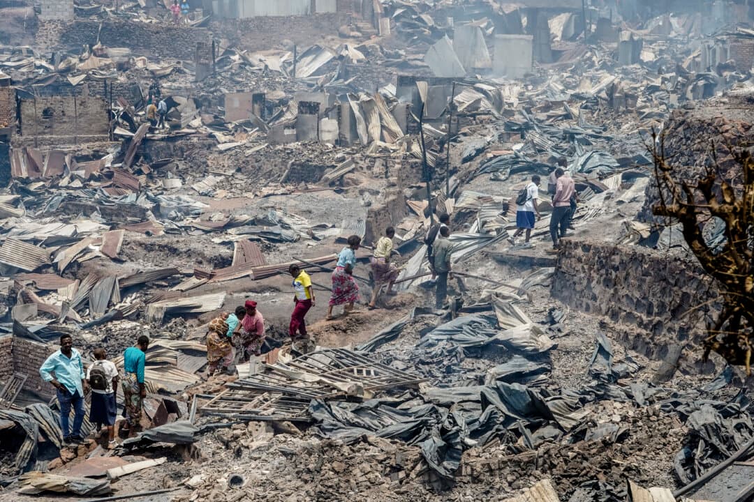 Residents walk among the debris of a fire that ravaged a school in Bukavu, Congo, on Sept. 10, 2026. The fire broke out on Sept. 9 in a school in the eastern Congolese city of Bukavu, causing a stampede that killed at least 14 children, local and health sources said. (Joseph Amani Alimasi/AFP via Getty Images)