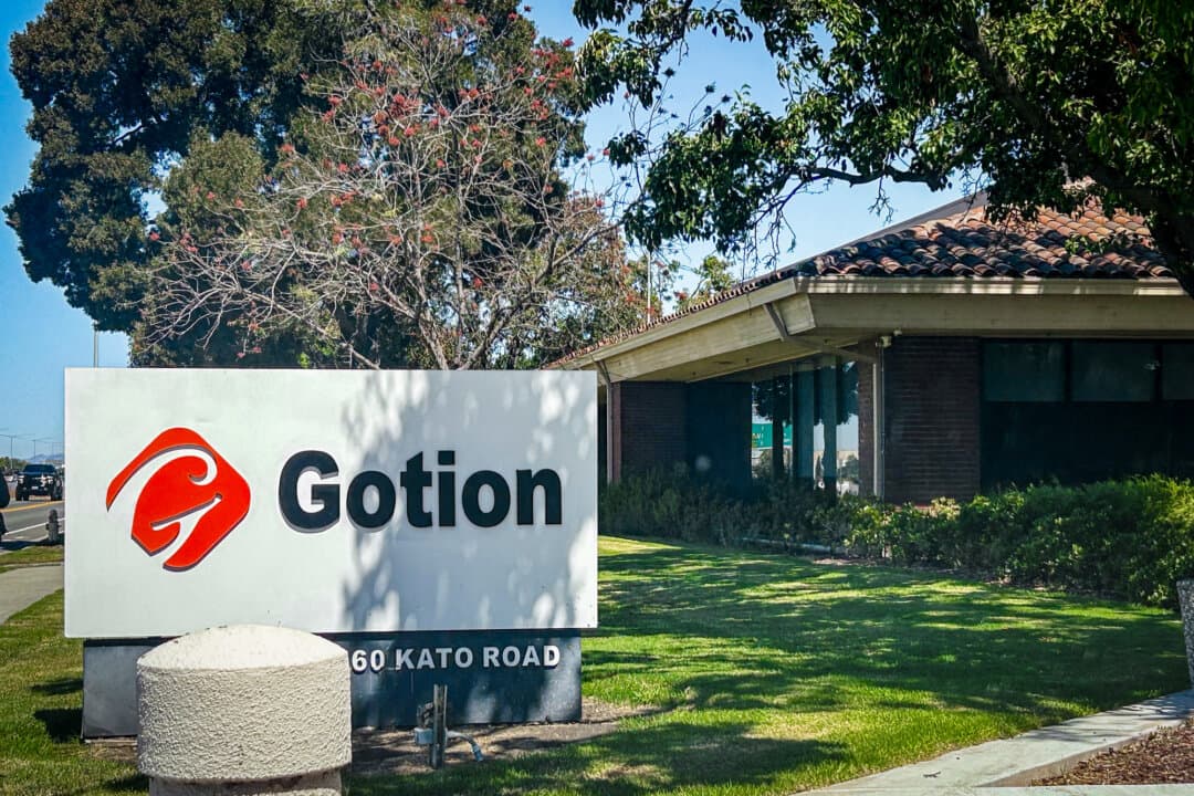 (Left) Illinois Gov. JB Pritzker (Center R) and Gotion representatives announce plans for a lithium battery plant in Manteno, Ill., in Sept. 8, 2023. (Right) The headquarters of Gotion Inc., in Fremont, Calif., on Aug. 26, 2026. (Courtesy of Gov. J.B. Pritzker's office, Dylan Morgan/The Epoch Times)