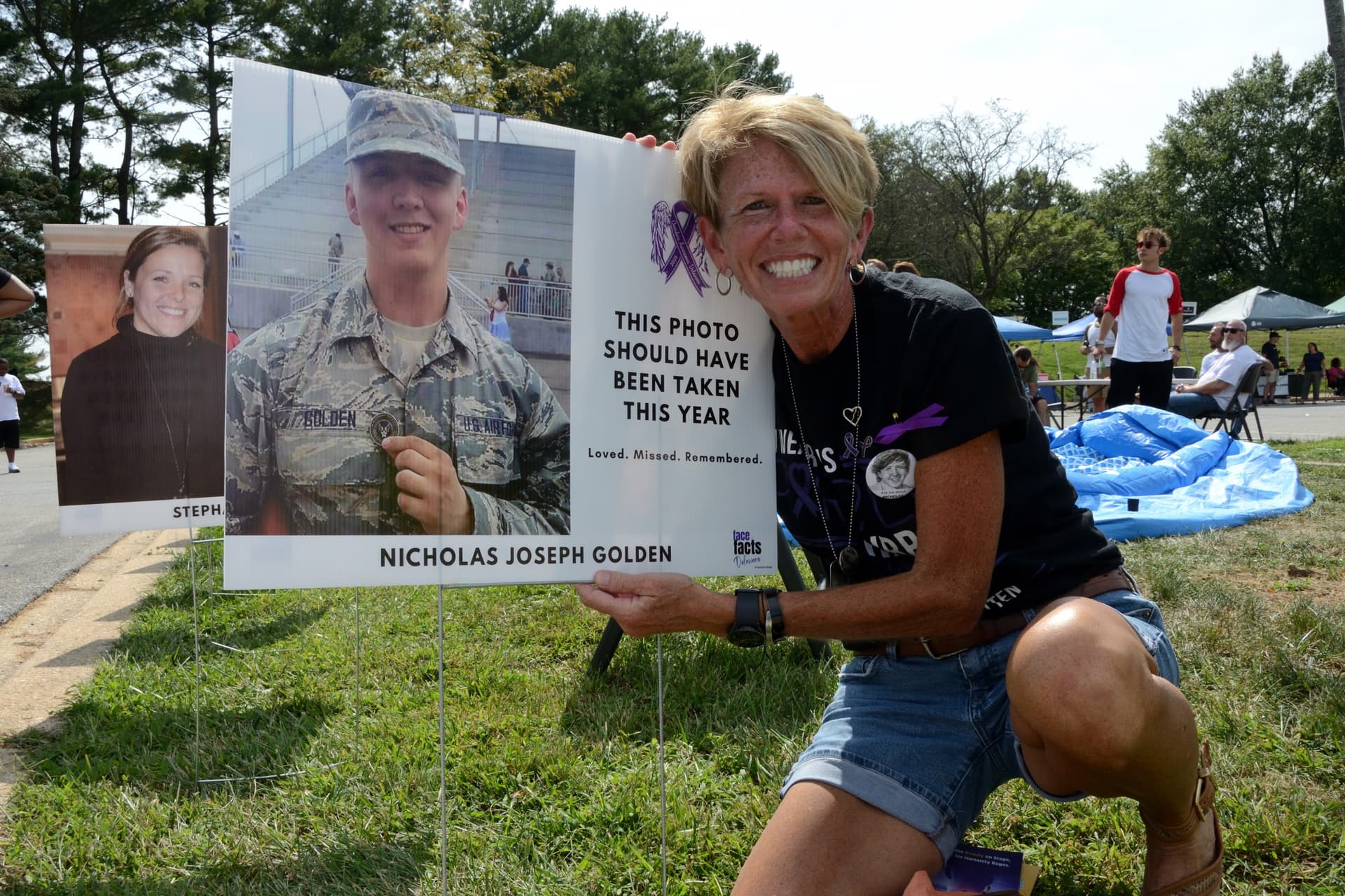Earlene Golden, an early childhood teacher, holds a memorial sign for her son, Nicholas Joseph Golden, displaying his photograph in a military uniform and a poignant message at Overdose Awareness Day Delaware on Sept. 12, 2026. (Frank Liang/The Epoch Times)