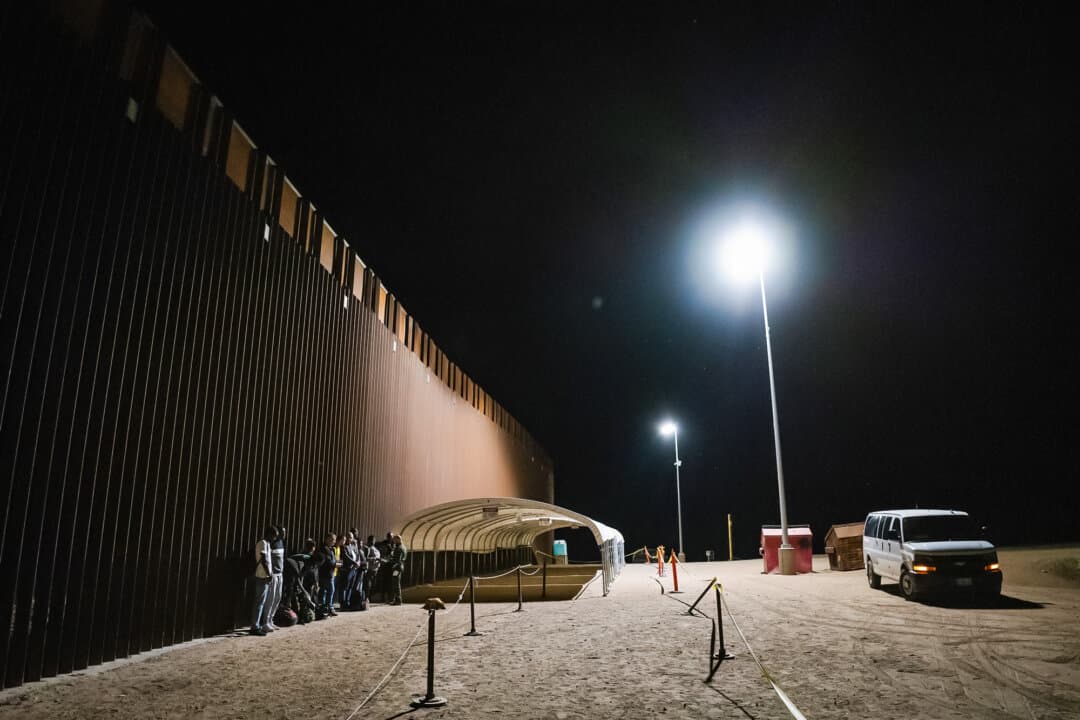 Illegal immigrants prepare to be transported by bus to processing faciities in Yuma, Ariz., on May 18, 2023. (John Fredricks/The Epoch Times)