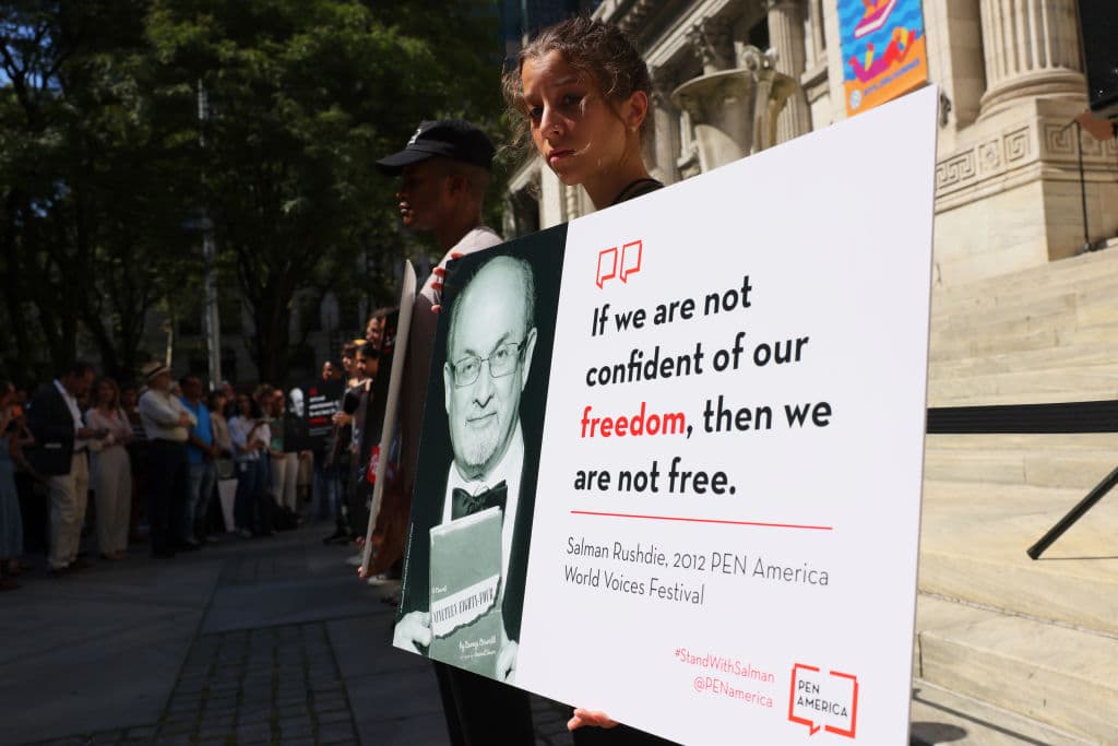People hold signs at the steps of the New York Public Library to show support for Salman Rushdie on Aug. 19, 2022, a week after he was attacked. (Michael M. Santiago/Getty Images)