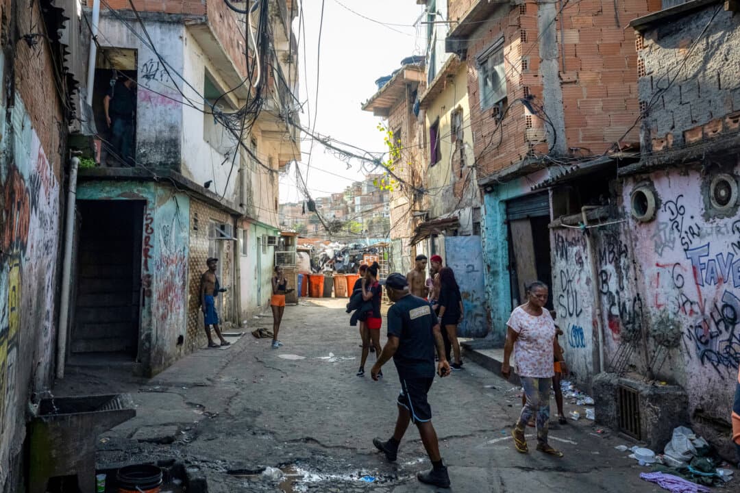 People walk on a street in the Metro-Mangueira favela in Rio de Janeiro on Aug. 12, 2026. Brazilian presidential candidate Renan Santos has vowed to get rid of the favelas, informal settlements that harbor much of the country's organized crime. (Pablo Porciuncula/AFP via Getty Images)