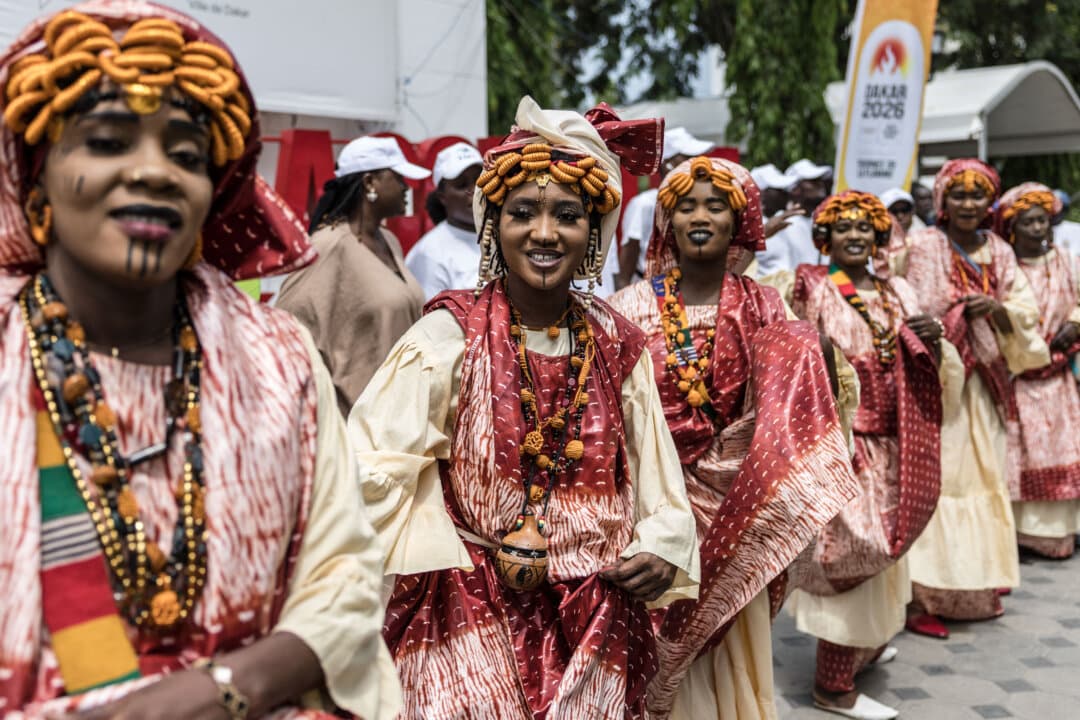 Performers in traditional clothing dance during a ceremony marking the start of the Youth Olympic Flame's 46-day tour in Dakar, Senegal, on Sept. 14, 2026. The flame will travel across Senegal's 14 regions before returning to Dakar for the opening ceremony on Oct. 31. (Patrick Meinhardt/AFP via Getty Images)