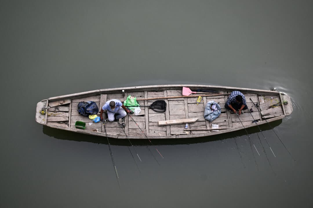 People fish in the Jhelum River in Srinagar, India, on Sept. 15, 2026. (Tauseef Mustafa/AFP via Getty Images)