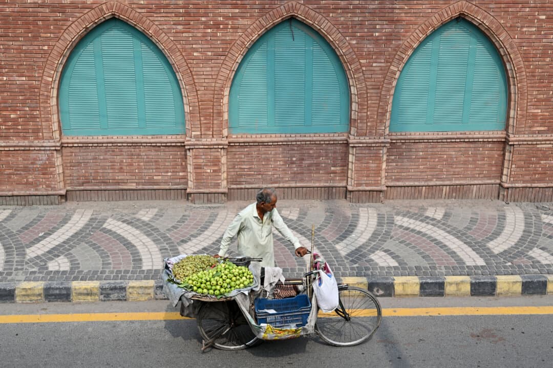 A fruit vendor pushes his bicycle along a street in Lahore, Pakistan, on Sept. 15, 2026. (Arif Ali/AFP via Getty Images)