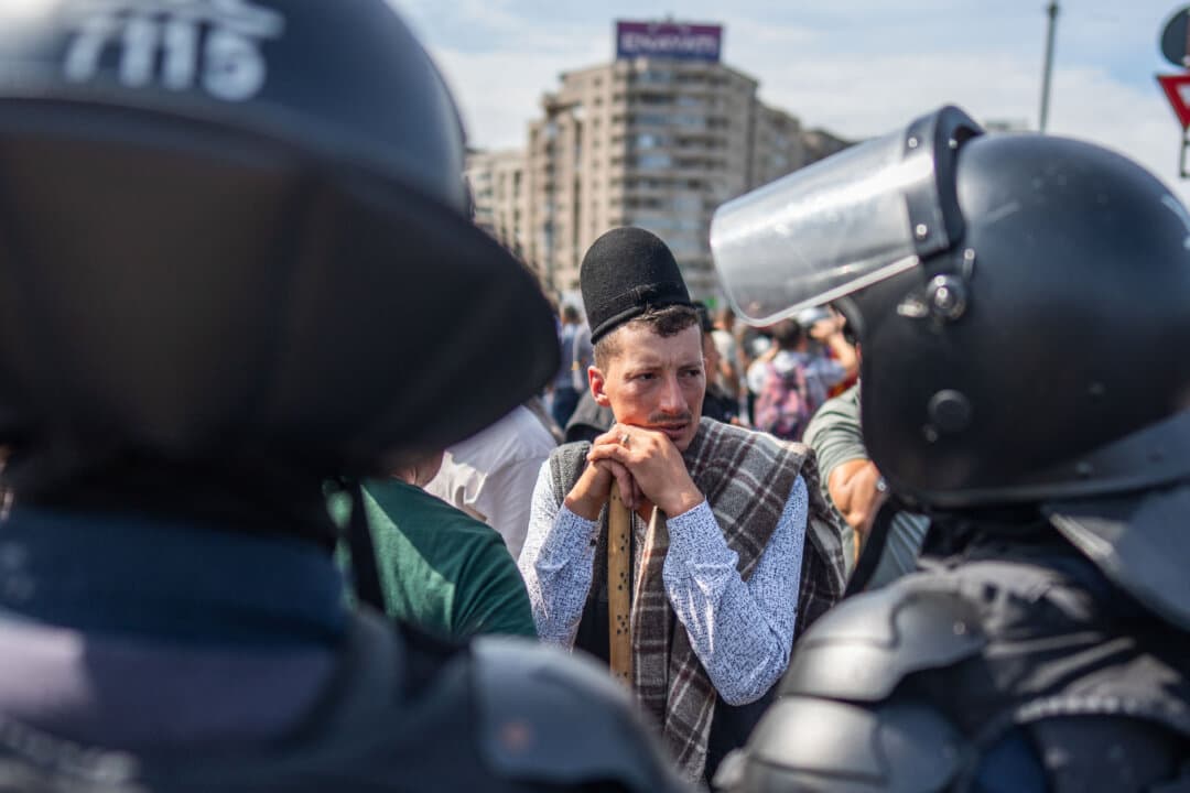 Police officers stand next to a shepherd during a protest started by disgruntled farmers and shepherds against the Romanian government's policies in Bucharest, Romania, on Sept. 15, 2026. About 2,000 people demonstrated outside government headquarters, with clashes reported between protesters and police. (Mihai Barbu/AFP via Getty Images)